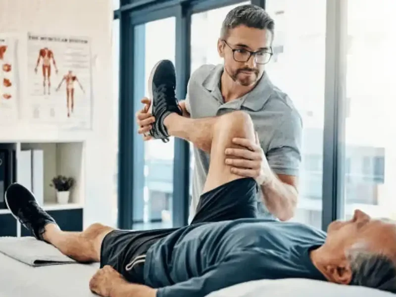 Physical therapist assessing a patient's knee movement and mobility